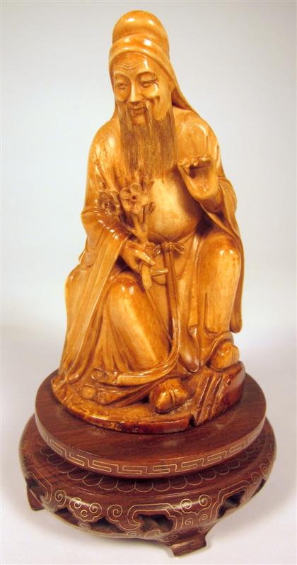 Appraisal: Chinese mammoth ivory figure of a scholarSeated and stained carved