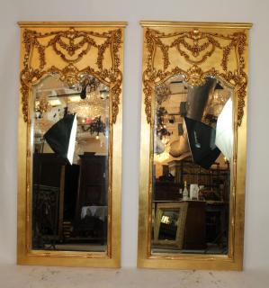 Appraisal: Pair of gold trumeau beveled mirrors with floral carvings h