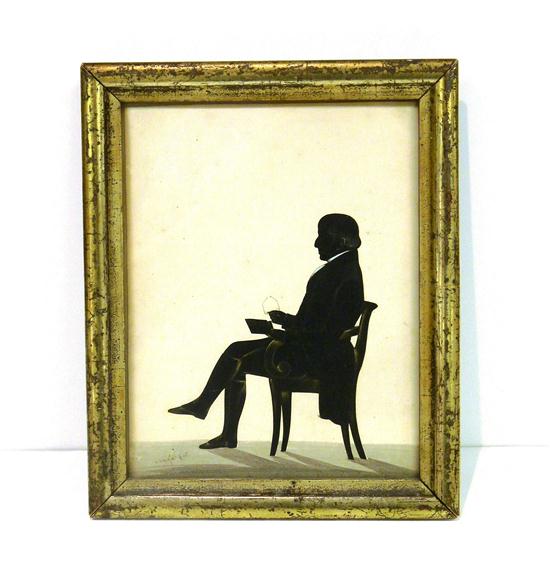 Appraisal: th C silhouette of seated man with book and glasses