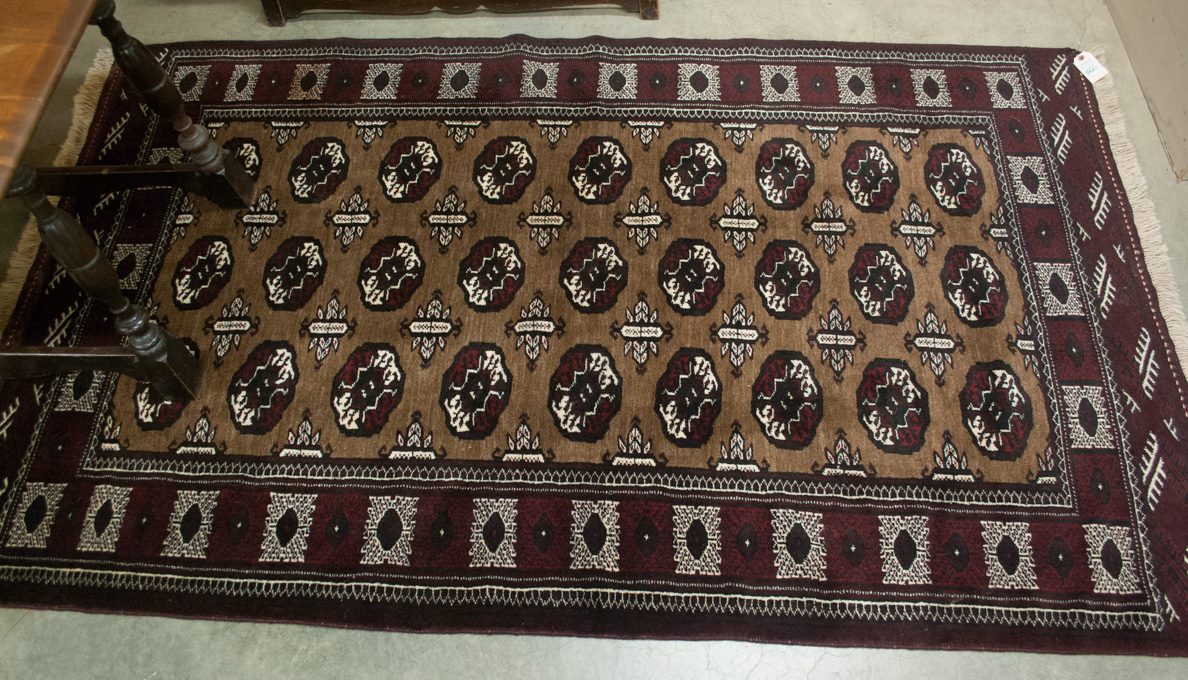 Appraisal: AFGHAN BOKHARA AREA RUG featuring a rectangular brown field of