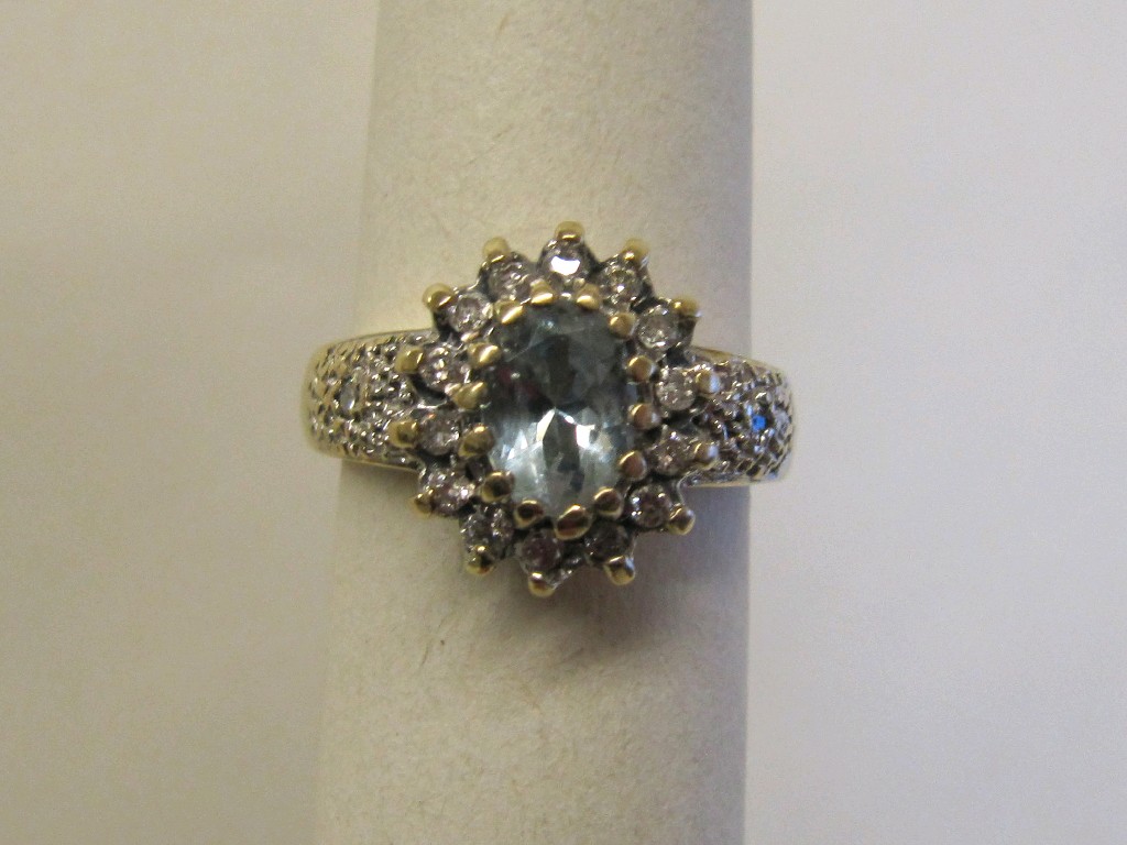 Appraisal: Nine carat gold blue topaz and diamond cluster ring