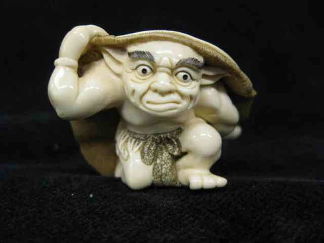 Appraisal: Carved Ivory Netsuke of an Oniunder a hat fine polychrome