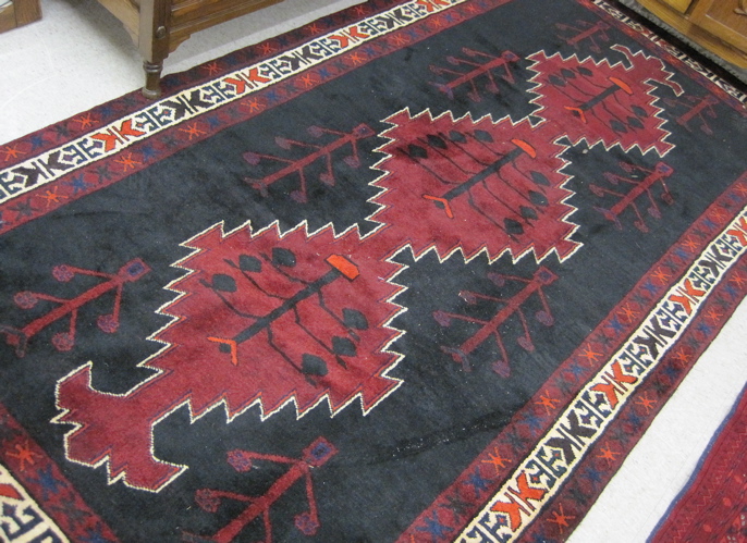 Appraisal: PERSIAN TRIBAL CARPET featuring a column of three interconnected red