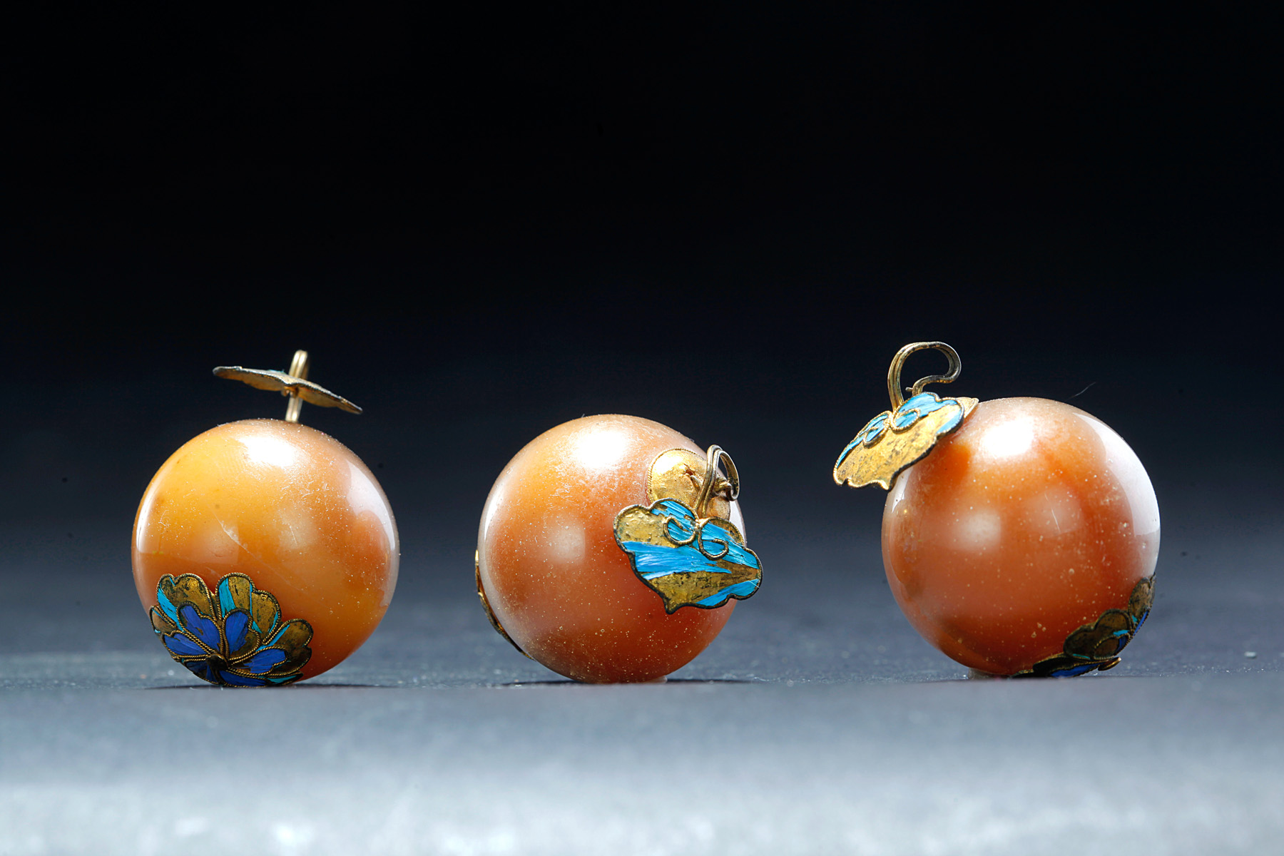 Appraisal: THREE CHINESE AMBER BEADS Eighteenth- th century Each has gilt