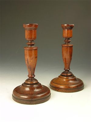 Appraisal: A pair of th century turned oak candlesticks in cm