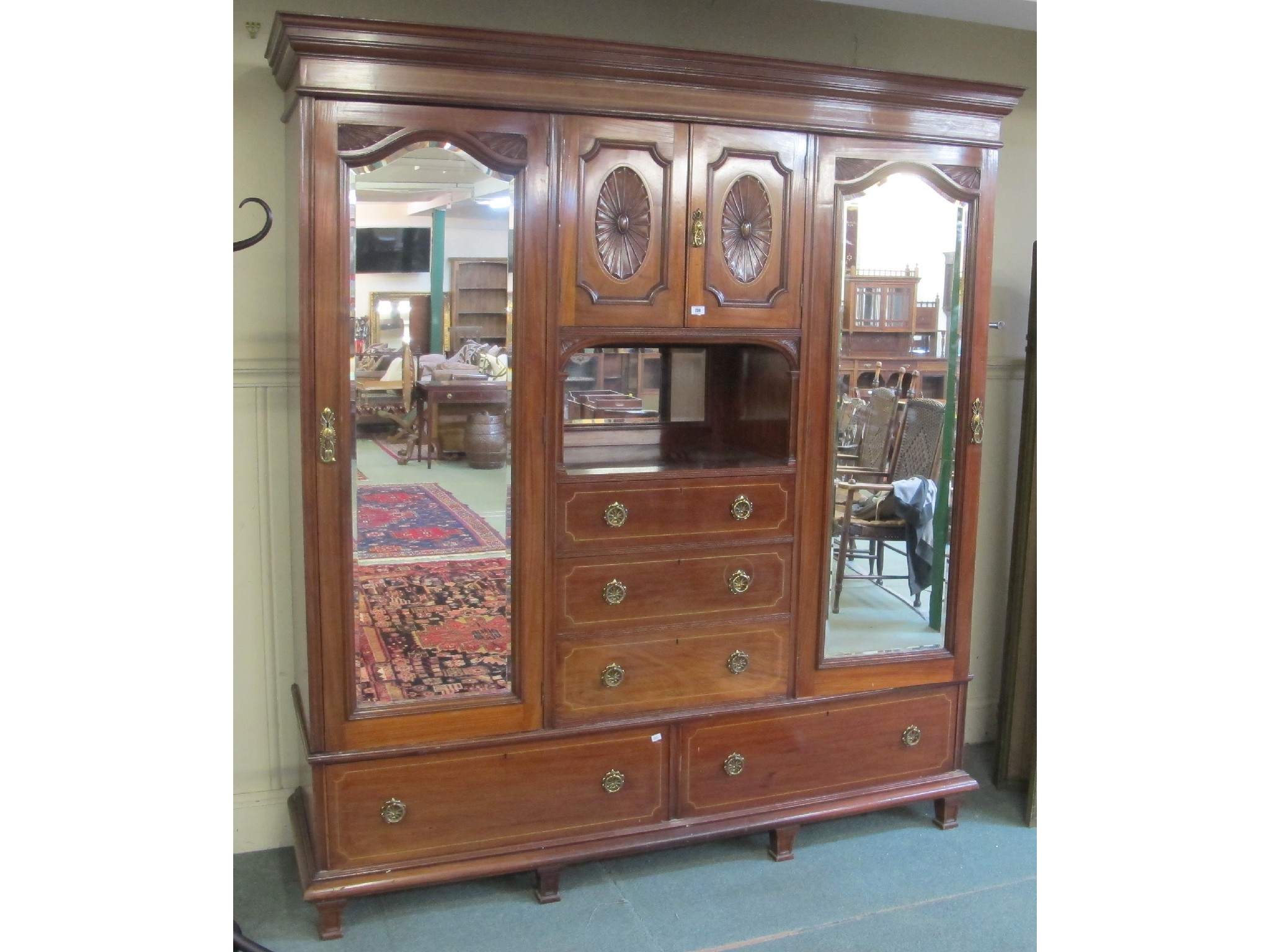 Appraisal: An Edwardian mahogany mirrored door wardrobe with central cabinet above