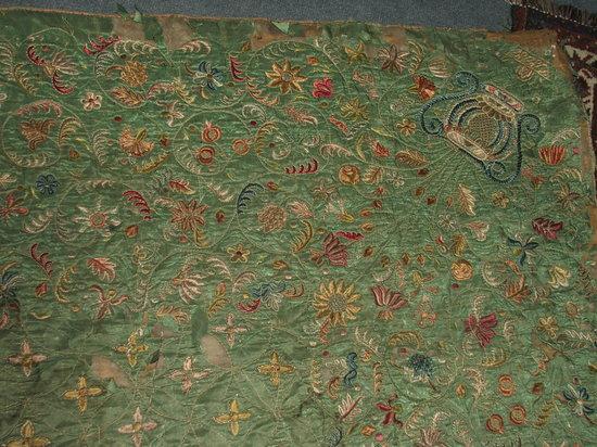 Appraisal: AN ANTIQUE NEEDLEWORK BED COVER decorated with stylised trailing flowers