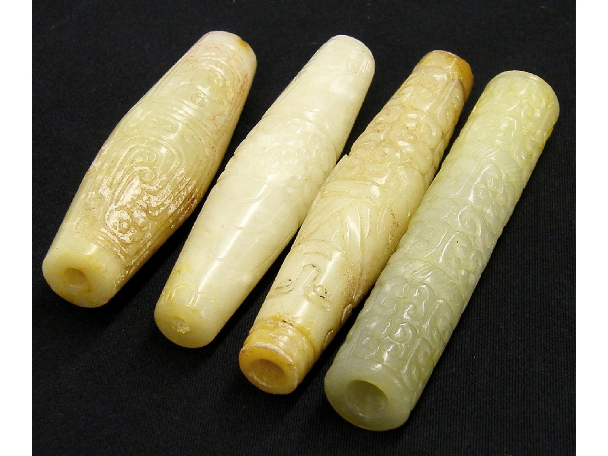 Appraisal: Four various interesting carved jade celadon and pale celadon beads