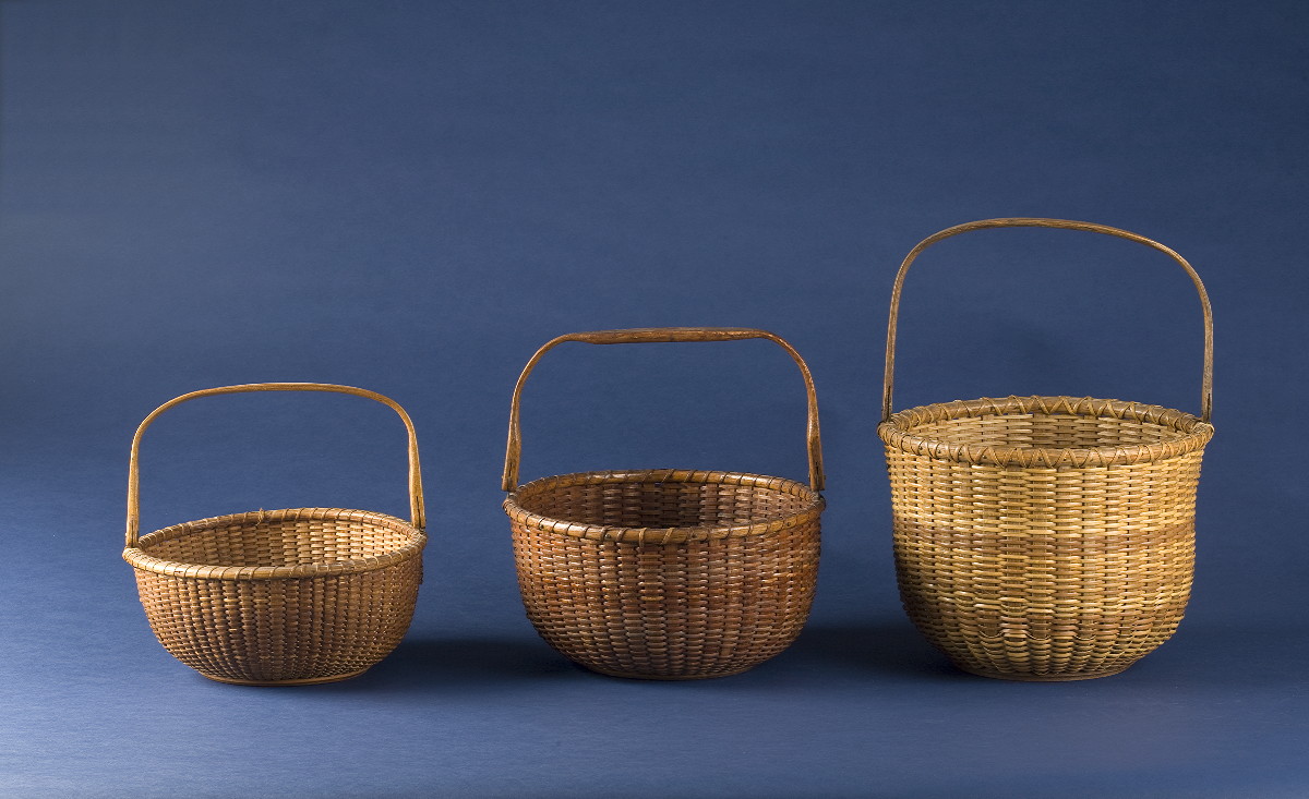 Appraisal: TALL CIRCULAR NANTUCKET BASKET WITH SWING HANDLE The shaped handle