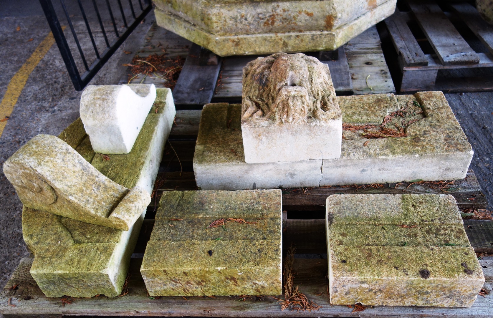 Appraisal: A carved limestone wall fountain with face mask and canted