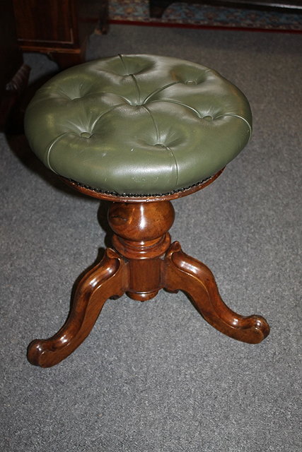 Appraisal: A VICTORIAN WALNUT REVOLVING PIANO STOOL with leather button top