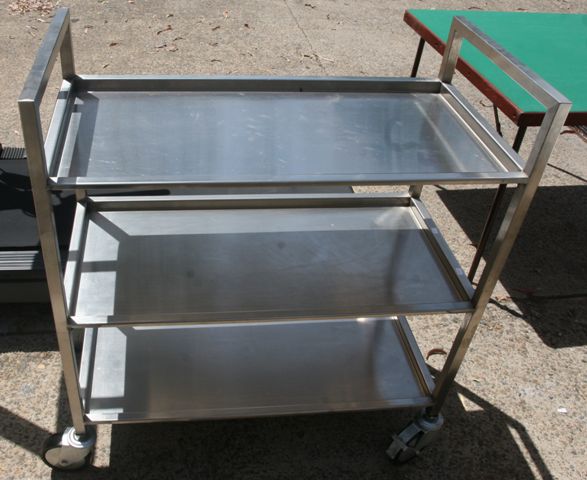 Appraisal: A stainless steel tea trolley together with a two tier