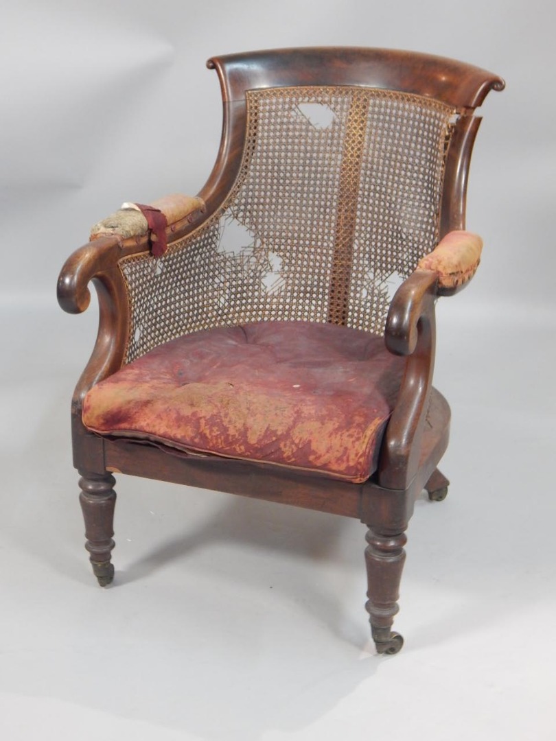 Appraisal: A George IV mahogany bergere armchair with a scroll carved