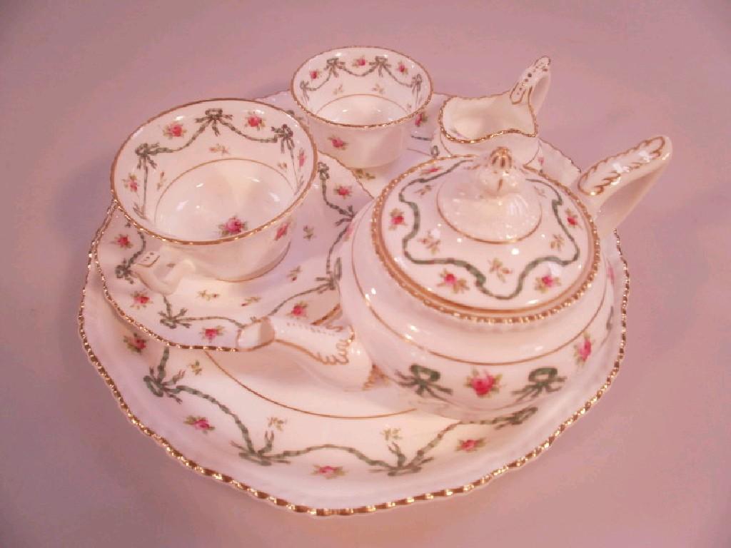 Appraisal: An Edwardian Coalport bachelor teaset decorated with rosebuds and swags