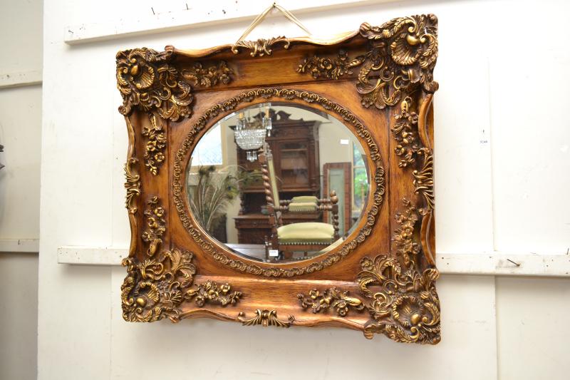 Appraisal: AN OVAL BEVELLED EDGE MIRROR IN AN ORNATE GILT RECTANGULAR