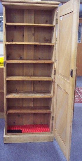 Appraisal: A pine cupboard the panel door enclosing shelves on a