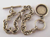 Appraisal: A white metal tests silver bracelet with coin pendant charm