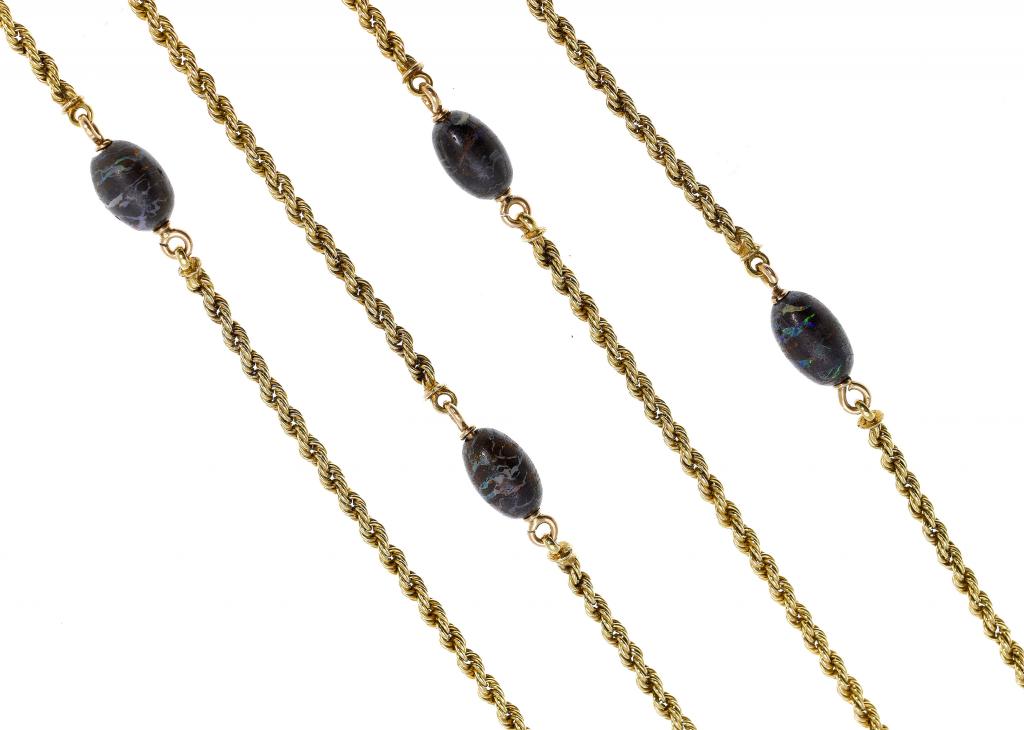 Appraisal: A GOLD GUARD CHAIN of rope pattern with opal beads