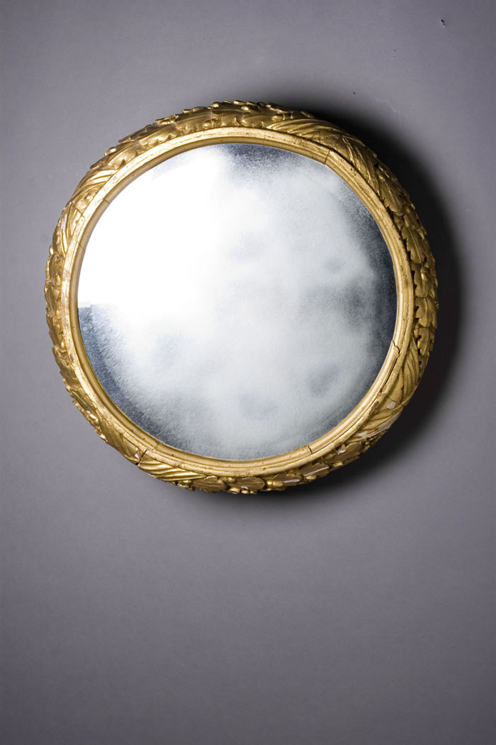 Appraisal: CLASSICAL CARVED GILTWOOD MIRROR The circular beveled mirror plate within