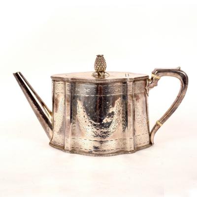 Appraisal: A Victorian silver teapot WH London of serpentine outline engraved