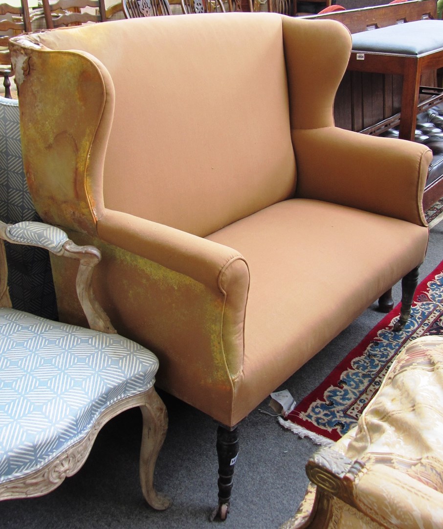 Appraisal: An early th century high wingback sofa on turned mahogany