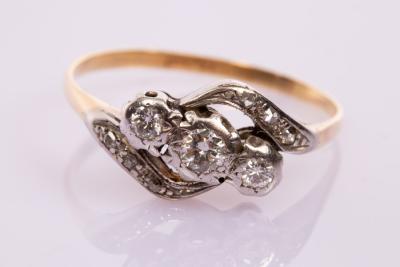 Appraisal: A three-stone diamond crossover ring set in platinum and ct