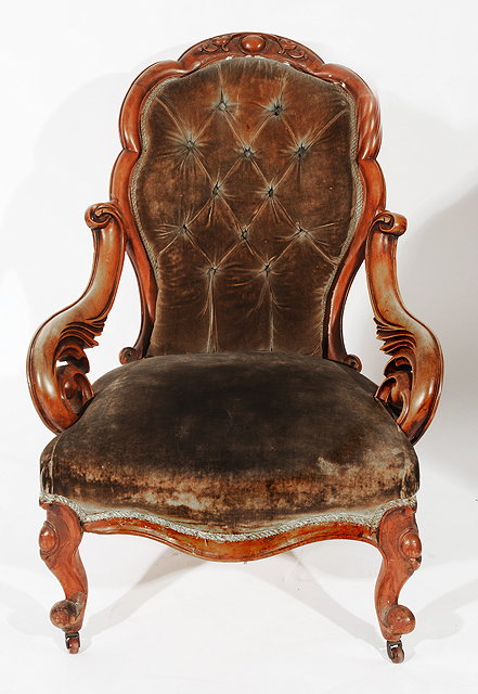 Appraisal: A VICTORIAN WALNUT OPEN ARM CHAIR shaped button upholstered back