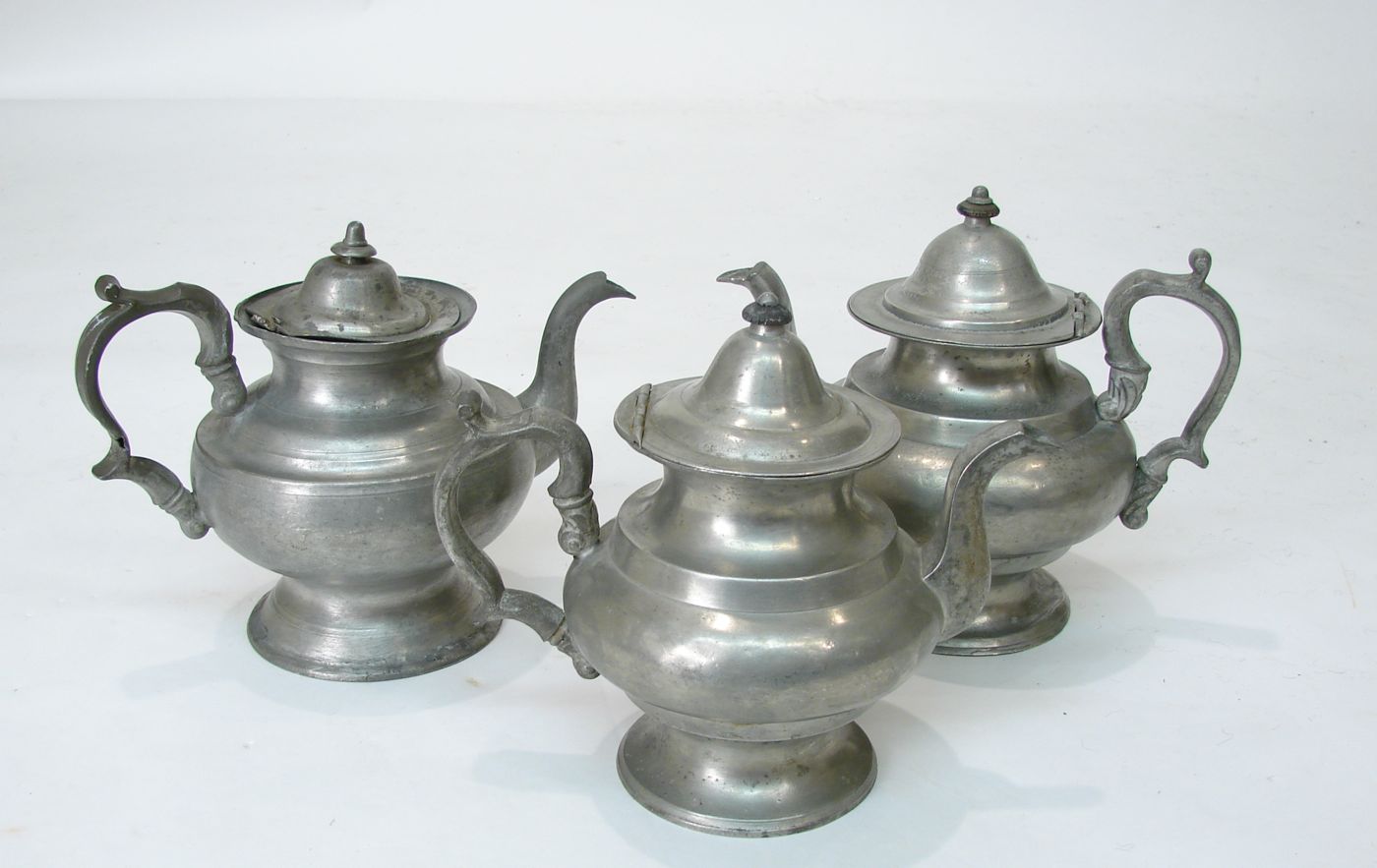 Appraisal: THREE ANTIQUE PEWTER TEAPOTS Teapot by William McQuilken of Philadelphia