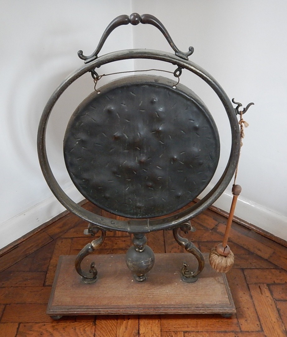 Appraisal: A Victorian dinner gong on brass frame and scroll mounts