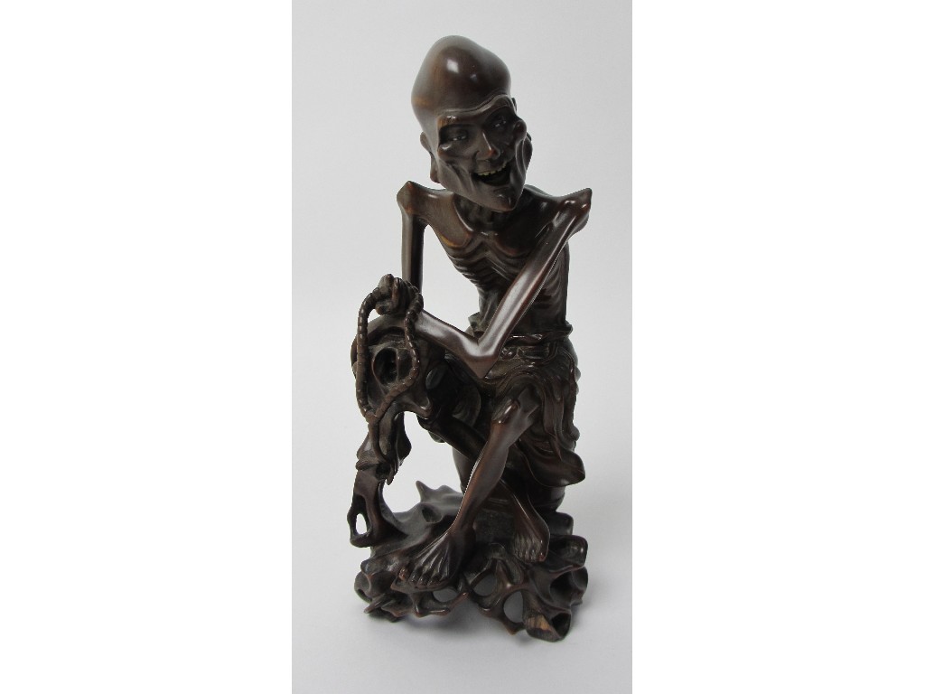 Appraisal: A Chinese carved wood figure of a Senin seated holding