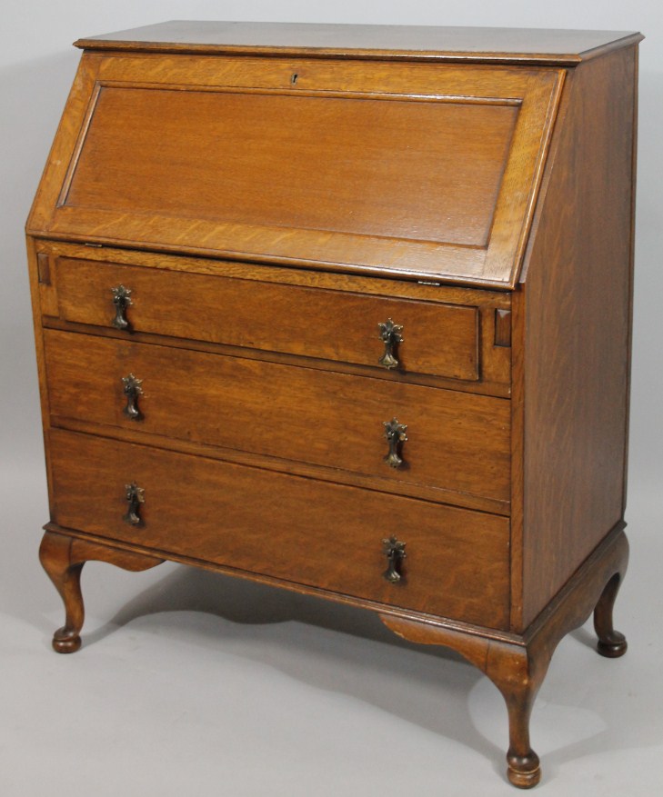 Appraisal: A mid- thC oak bureau the overhanging top raised above