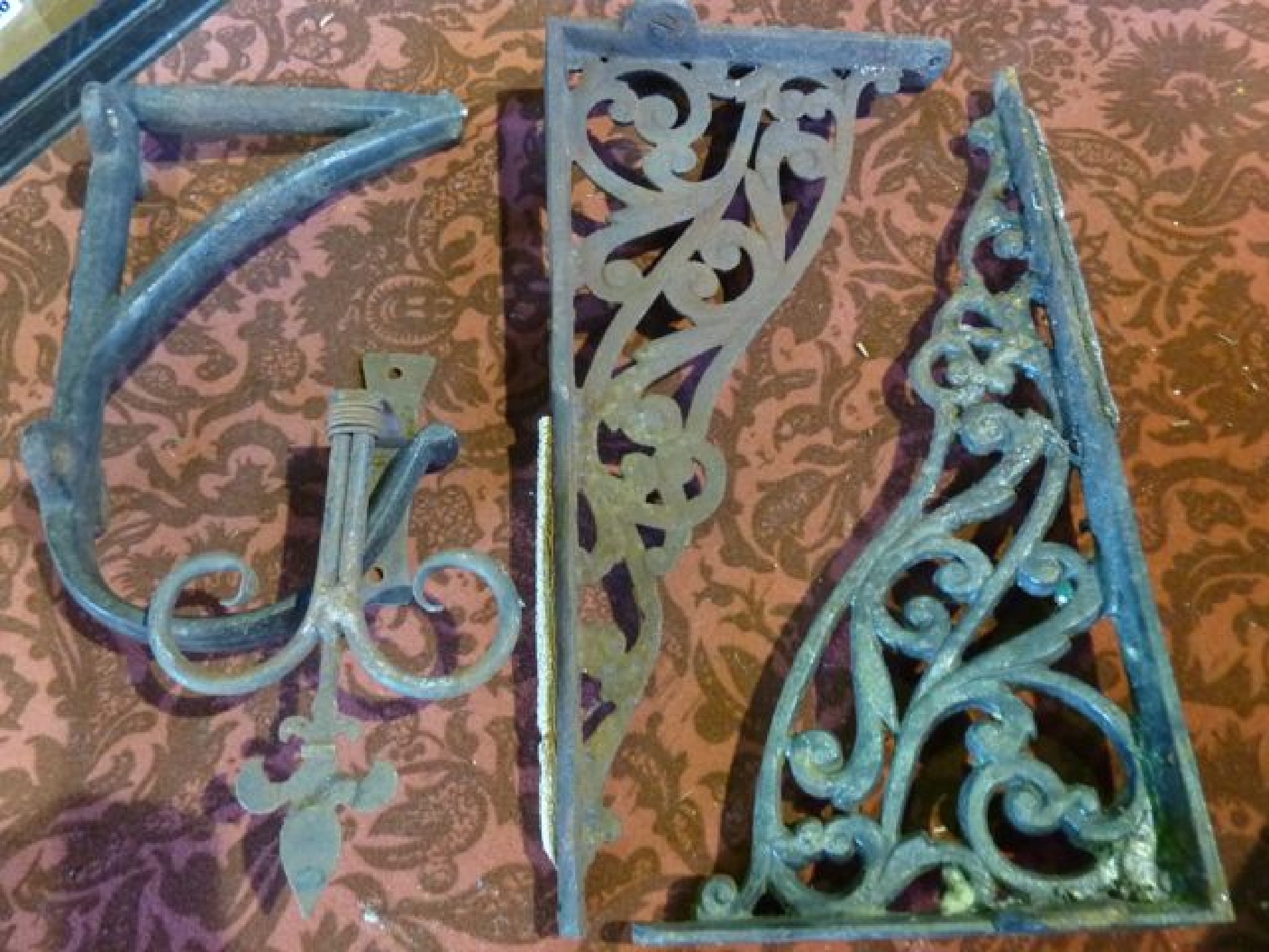 Appraisal: A pair of iron L shaped brackets with pier scrolling