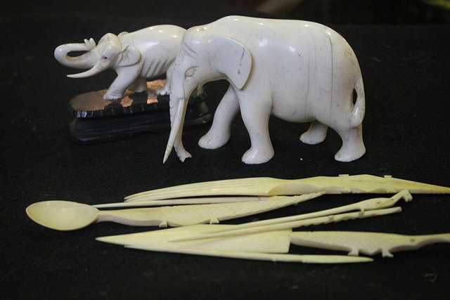 Appraisal: TWO CARVED IVORY ELEPHANTS together with a small collection of