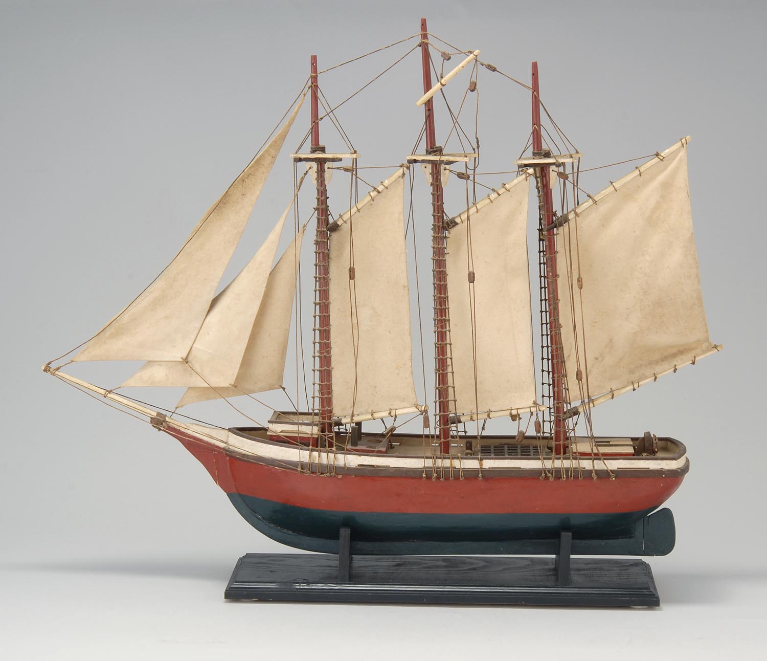 Appraisal: WOOD MODEL OF A THREE-MASTED SCHOONER Hull in red and