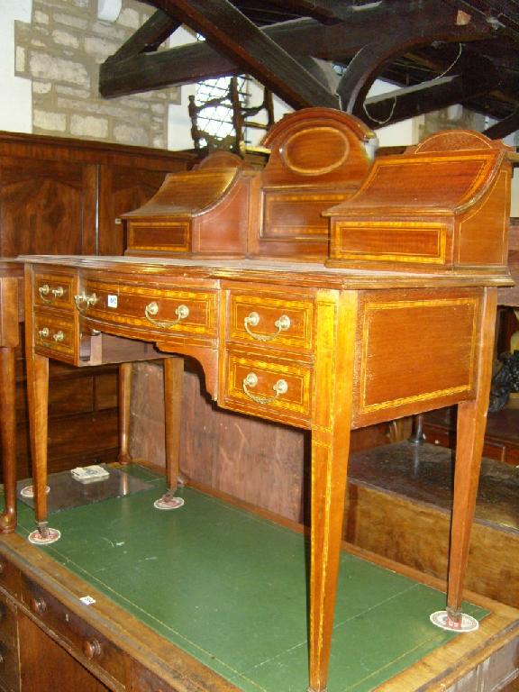 Appraisal: An inlaid Edwardian mahogany kneehole writing desk the bowed break