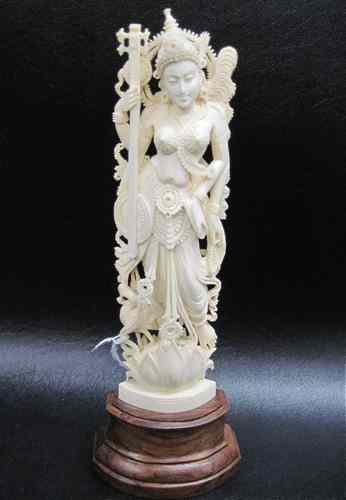 Appraisal: IVORY CARVED FEMALE FIGURE standing on a lotus throne holding