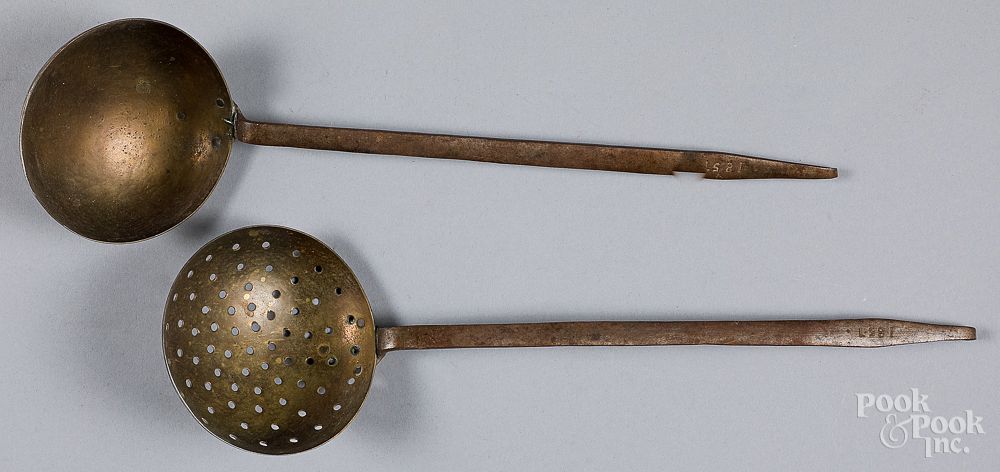 Appraisal: Wrought iron and brass ladle and a straining ladl Wrought