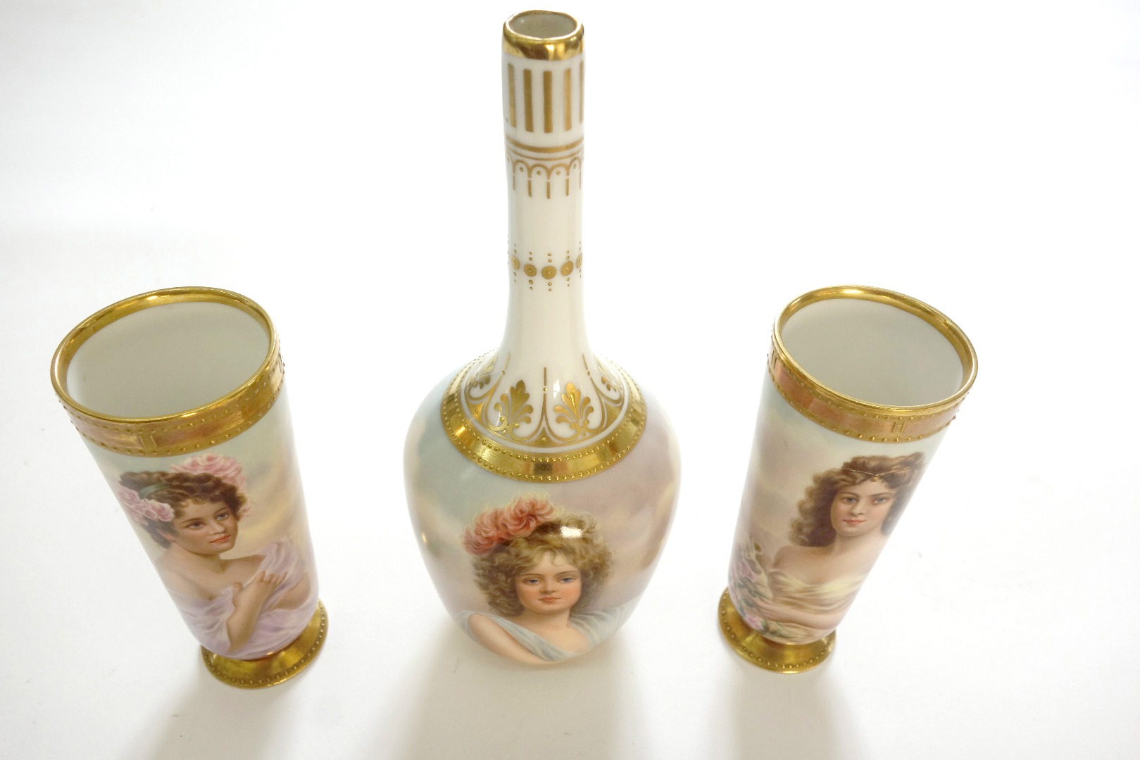 Appraisal: A Garniture of three 'Vienna' style porcelain vases each painted