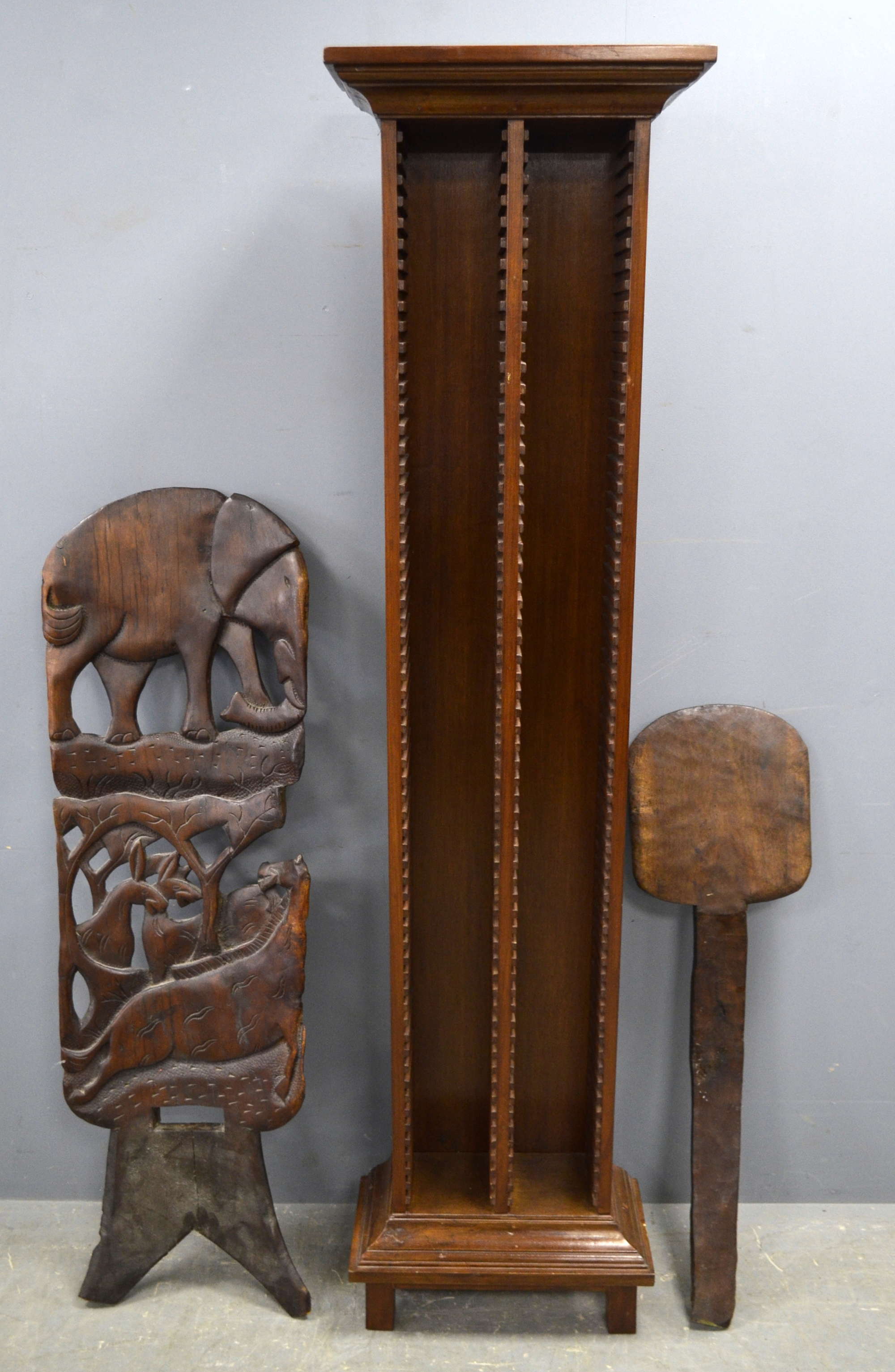 Appraisal: A carved African chair and a floor standing CD rack