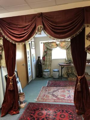 Appraisal: A pair of red velvet swagged curtains with tie backs