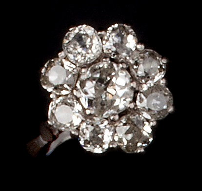 Appraisal: A DIAMOND CLUSTER RING claw set with graduated cushion-shaped old-cut