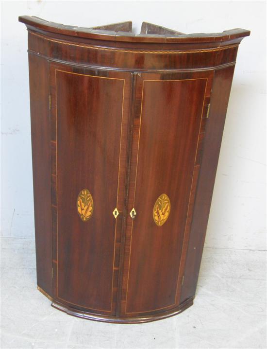 Appraisal: George III mahogany and marquetry inlaid bow fronted corner cupboard