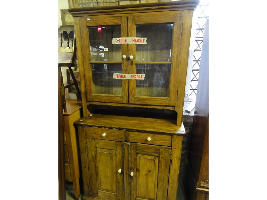 Appraisal: A stripped pine kitchen dresser the upper section enclosed by