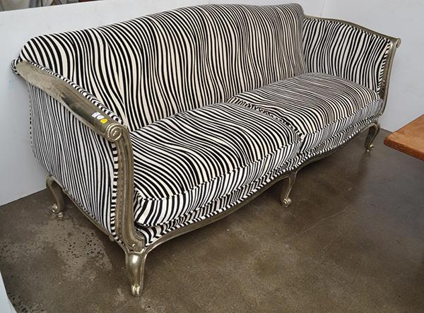 Appraisal: A SILVERFOIL OVERLAID THREE SEAT CANAPEupholstered in zebra striped fabric