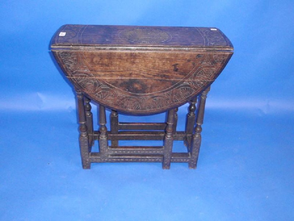 Appraisal: A carved oak gate leg table with drop leaves cm