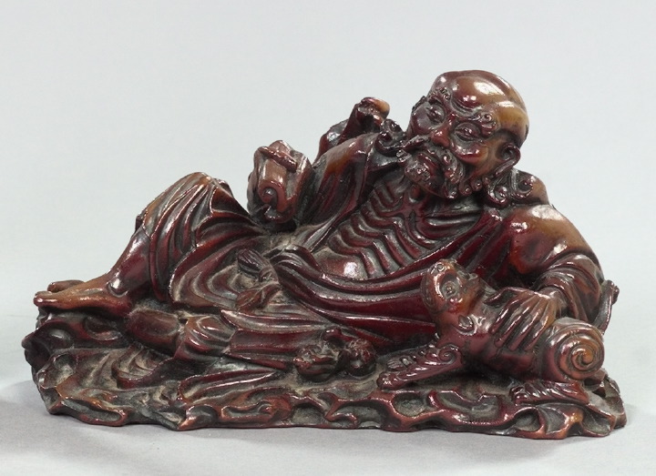 Appraisal: Kuang-Hsu Elaborately Carved and Lacquer-Patinated Composition Figure depicting a reclining