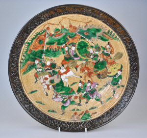 Appraisal: A Japanese charger decorated with fighting soldiers in a mountainous