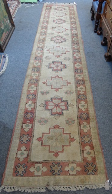 Appraisal: A Turkish runner the beige field with ten single medallions