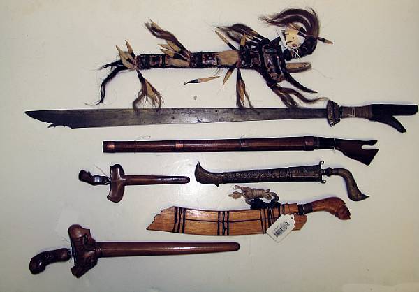 Appraisal: Seven Indonesian edged weapons A kampilan a horn-hilted klewang with