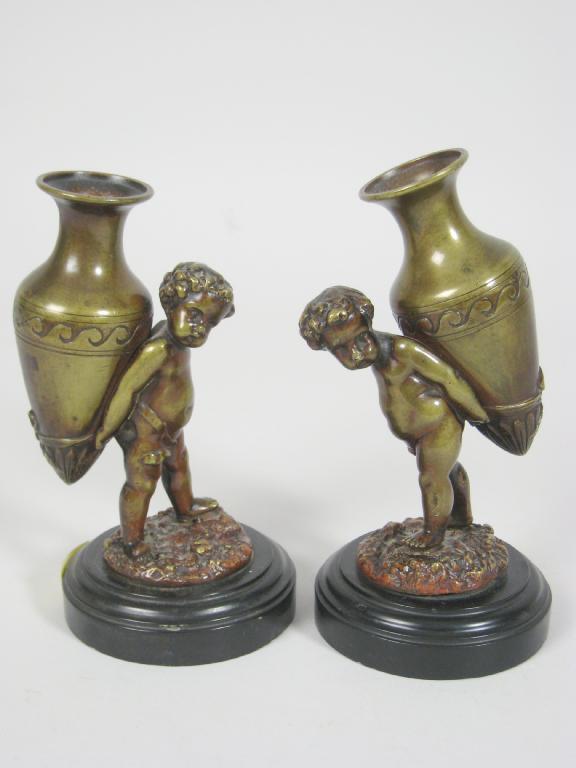 Appraisal: Pair of bronze Figures of Putti carrying urns on circular